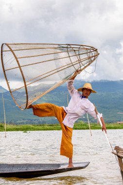 Inle Lake, Myanmar - 30 Ağustos 2016: Özel el yapımı ağı olan bir teknede tanımlanamayan Birmanyalı balıkçı. Bu Myanmar balıkçılık geleneksel yoludur