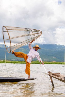 Inle Lake, Myanmar - 30 Ağustos 2016: Özel el yapımı ağı olan bir teknede tanımlanamayan Birmanyalı balıkçı. Bu Myanmar balıkçılık geleneksel yoludur