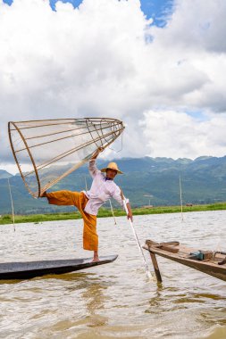 Inle Lake, Myanmar - 30 Ağustos 2016: Özel el yapımı ağı olan bir teknede tanımlanamayan Birmanyalı balıkçı. Bu Myanmar balıkçılık geleneksel yoludur