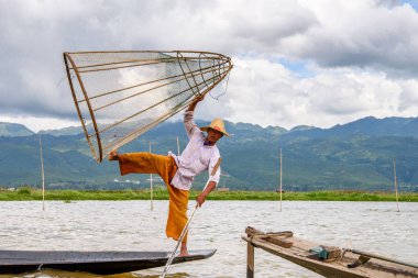 Inle Lake, Myanmar - 30 Ağustos 2016: Özel el yapımı ağı olan bir teknede tanımlanamayan Birmanyalı balıkçı. Bu Myanmar balıkçılık geleneksel yoludur