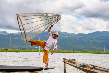 Inle Lake, Myanmar - 30 Ağustos 2016: Özel el yapımı ağı olan bir teknede tanımlanamayan Birmanyalı balıkçı. Bu Myanmar balıkçılık geleneksel yoludur