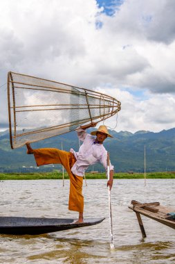 Inle Lake, Myanmar - 30 Ağustos 2016: Özel el yapımı ağı olan bir teknede tanımlanamayan Birmanyalı balıkçı. Bu Myanmar balıkçılık geleneksel yoludur