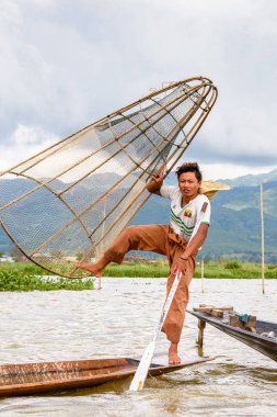 Inle Lake, Myanmar - 30 Ağustos 2016: Özel el yapımı ağı olan bir teknede tanımlanamayan Birmanyalı balıkçı. Bu Myanmar balıkçılık geleneksel yoludur