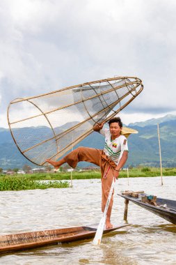 Inle Lake, Myanmar - 30 Ağustos 2016: Özel el yapımı ağı olan bir teknede tanımlanamayan Birmanyalı balıkçı. Bu Myanmar balıkçılık geleneksel yoludur
