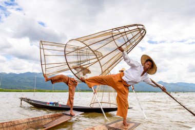 Inle Lake, Myanmar - 30 Ağustos 2016: Özel el yapımı ağı olan bir teknede tanımlanamayan Birmanyalı balıkçı. Bu Myanmar balıkçılık geleneksel yoludur