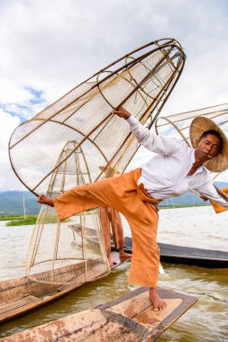 Inle Lake, Myanmar - 30 Ağustos 2016: Özel el yapımı ağı olan bir teknede tanımlanamayan Birmanyalı balıkçı. Bu Myanmar balıkçılık geleneksel yoludur