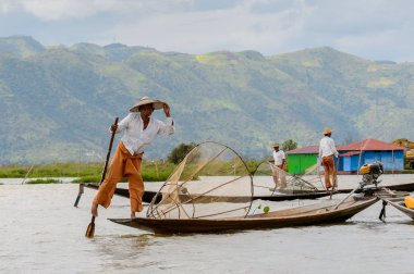 Inle Lake, Myanmar - 30 Ağustos 2016: Özel el yapımı ağı olan bir teknede tanımlanamayan Birmanyalı balıkçı. Bu Myanmar balıkçılık geleneksel yoludur