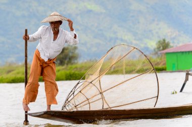 Inle Lake, Myanmar - 30 Ağustos 2016: Özel el yapımı ağı olan bir teknede tanımlanamayan Birmanyalı yerel balıkçı. Bu Myanmar balıkçılık geleneksel yoludur