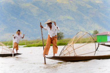 Inle Lake, Myanmar - 30 Ağustos 2016: Özel el yapımı ağı olan bir teknede tanımlanamayan Birmanyalı yerel balıkçı. Bu Myanmar balıkçılık geleneksel yoludur