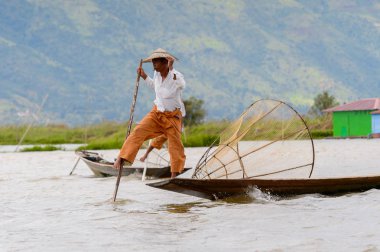 Inle Lake, Myanmar - 30 Ağustos 2016: Özel el yapımı ağı olan bir teknede tanımlanamayan Birmanyalı yerel balıkçı. Bu Myanmar balıkçılık geleneksel yoludur