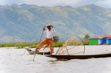 Inle Lake, Myanmar - 30 Ağustos 2016: Özel el yapımı ağı olan bir teknede tanımlanamayan Birmanyalı yerel balıkçı. Bu Myanmar balıkçılık geleneksel yoludur