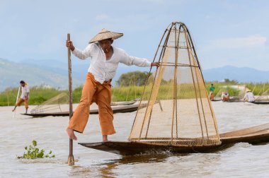 Inle Lake, Myanmar - 30 Ağustos 2016: Özel el yapımı ağı olan bir teknede tanımlanamayan Birmanyalı balıkçı. Bu Myanmar balıkçılık geleneksel yoludur