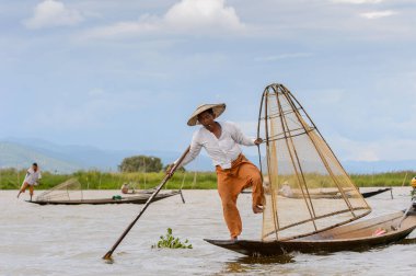 Inle Lake, Myanmar - 30 Ağustos 2016: Özel el yapımı ağı olan bir teknede tanımlanamayan Birmanyalı balıkçı. Bu Myanmar balıkçılık geleneksel yoludur