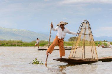 Inle Lake, Myanmar - 30 Ağustos 2016: Özel el yapımı ağı olan bir teknede tanımlanamayan Birmanyalı balıkçı. Bu Myanmar balıkçılık geleneksel yoludur