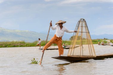 Inle Lake, Myanmar - 30 Ağustos 2016: Özel el yapımı ağı olan bir teknede tanımlanamayan Birmanyalı balıkçı. Bu Myanmar balıkçılık geleneksel yoludur
