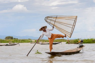 Inle Lake, Myanmar - 30 Ağustos 2016: Özel el yapımı ağı olan bir teknede tanımlanamayan Birmanyalı balıkçı. Bu Myanmar balıkçılık geleneksel yoludur