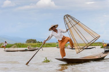 Inle Lake, Myanmar - 30 Ağustos 2016: Özel el yapımı ağı olan bir teknede tanımlanamayan Birmanyalı balıkçı. Bu Myanmar balıkçılık geleneksel yoludur