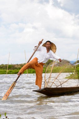 Inle Lake, Myanmar - 30 Ağustos 2016: Özel el yapımı ağı olan bir teknede tanımlanamayan Birmanyalı balıkçı. Bu Myanmar balıkçılık geleneksel yoludur