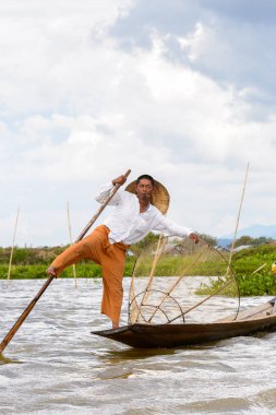 Inle Lake, Myanmar - 30 Ağustos 2016: Özel el yapımı ağı olan bir teknede tanımlanamayan Birmanyalı balıkçı. Bu Myanmar balıkçılık geleneksel yoludur