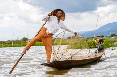 Inle Lake, Myanmar - 30 Ağustos 2016: Özel el yapımı ağı olan bir teknede tanımlanamayan Birmanyalı balıkçı. Bu Myanmar balıkçılık geleneksel yoludur