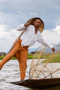 Inle Lake, Myanmar - 30 Ağustos 2016: Özel el yapımı ağı olan bir teknede tanımlanamayan Birmanyalı balıkçı. Bu Myanmar balıkçılık geleneksel yoludur