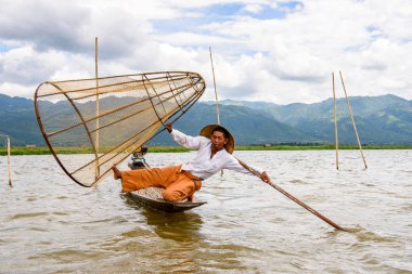 Inle Lake, Myanmar - 30 Ağustos 2016: Özel el yapımı ağı olan bir teknede tanımlanamayan Birmanyalı balıkçı. Bu Myanmar balıkçılık geleneksel yoludur