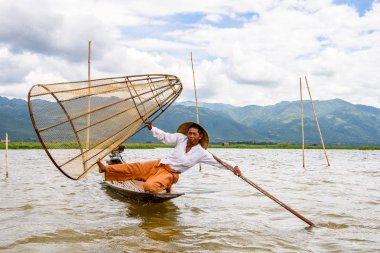Inle Lake, Myanmar - 30 Ağustos 2016: Özel el yapımı ağı olan bir teknede tanımlanamayan Birmanyalı balıkçı. Bu Myanmar balıkçılık geleneksel yoludur