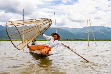 Inle Lake, Myanmar - 30 Ağustos 2016: Özel el yapımı ağı olan bir teknede tanımlanamayan Birmanyalı balıkçı. Bu Myanmar balıkçılık geleneksel yoludur