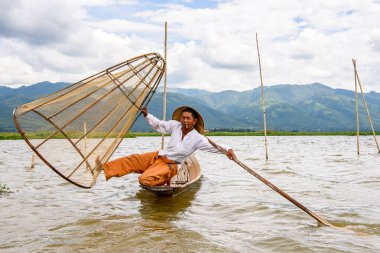 Inle Lake, Myanmar - 30 Ağustos 2016: Özel el yapımı ağı olan bir teknede tanımlanamayan Birmanyalı balıkçı. Bu Myanmar balıkçılık geleneksel yoludur