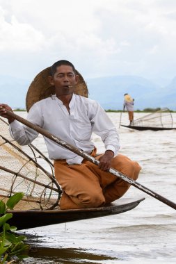 Inle Lake, Myanmar - 30 Ağustos 2016: Özel el yapımı ağı olan bir teknede tanımlanamayan Birmanyalı balıkçı. Bu Myanmar balıkçılık geleneksel yoludur