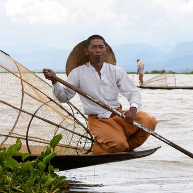 Inle Lake, Myanmar - 30 Ağustos 2016: Özel el yapımı ağı olan bir teknede tanımlanamayan Birmanyalı balıkçı. Bu Myanmar balıkçılık geleneksel yoludur