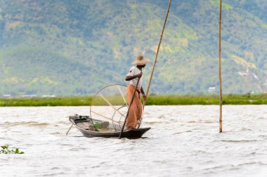 Inle Lake, Myanmar - 30 Ağustos 2016: Özel el yapımı ağı olan bir teknede tanımlanamayan Birmanyalı balıkçı. Bu Myanmar balıkçılık geleneksel yoludur