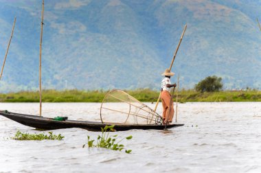 Inle Lake, Myanmar - 30 Ağustos 2016: Özel el yapımı ağı olan bir teknede tanımlanamayan Birmanyalı balıkçı. Bu Myanmar balıkçılık geleneksel yoludur