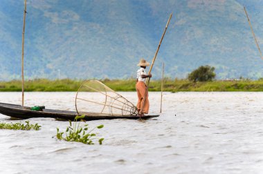 Inle Lake, Myanmar - 30 Ağustos 2016: Özel el yapımı ağı olan bir teknede tanımlanamayan Birmanyalı balıkçı. Bu Myanmar balıkçılık geleneksel yoludur