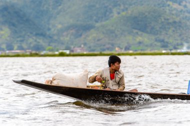 Inle Lake, Myanmar - 30 Ağustos 2016: Myanmar'ın Shan Eyaletinin Taunggyi İlçesi'nin Nyaungshwe İlçesi'nde bulunan bir tatlı su gölü olan Inle Sap'ın üzerinde bambu teknede bulunan tanımlanamayan Birmanyalı adam