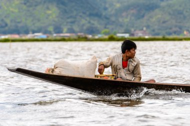 Inle Lake, Myanmar - 30 Ağustos 2016: Myanmar'ın Shan Eyaletinin Taunggyi İlçesi'nin Nyaungshwe İlçesi'nde bulunan bir tatlı su gölü olan Inle Sap'ın üzerinde bambu teknede bulunan tanımlanamayan Birmanyalı adam