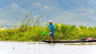 Inle Lake, Myanmar - 30 Ağustos 2016: Myanmar'ın Shan Eyaletinin Taunggyi İlçesi'nin Nyaungshwe İlçesi'nde bulunan bir tatlı su gölü olan Inle Sap'ın üzerinde bambu teknede bulunan tanımlanamayan Birmanyalı adam