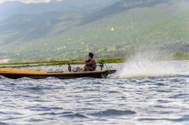 Inle Lake, Myanmar - 30 Ağustos 2016: Myanmar'ın Shan Eyaletinin Taunggyi İlçesi'nin Nyaungshwe İlçesi'nde bulunan bir tatlı su gölü olan Inle Sap'ın üzerinde bambu teknede bulunan tanımlanamayan Birmanyalı adam
