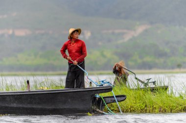 Inle Lake, Myanmar - 30 Ağustos 2016: Myanmar'ın Shan Eyaletinin Taunggyi İlçesi'nin Nyaungshwe İlçesi'nde bulunan bir tatlı su gölü olan Inle Sap'ın üzerinde bambu teknede bulunan tanımlanamayan Birmanyalı adam