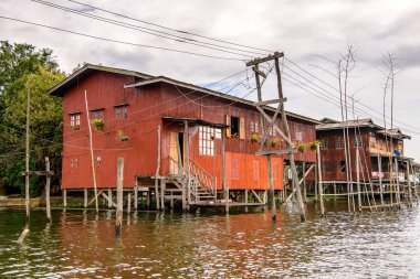 Inle Lake, Myanmar - 30 Ağustos 2016: Inle Sap üzerinde Inpawkhon köyünün evleri, Shan Eyaleti'nin Taunggyi İlçesi Nyaungshwe İlçesi'nde bir tatlı su gölü, Myanmar
