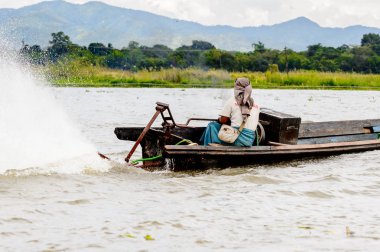 Inle Lake, Myanmar - 30 Ağustos 2016: Myanmar'ın Shan Eyaletinin Taunggyi İlçesi'nin Nyaungshwe İlçesi'nde bulunan bir tatlı su gölü olan Inle Sap'ın üzerinde bambu teknede bulunan tanımlanamayan Birmanyalı adam