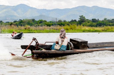 Inle Lake, Myanmar - 30 Ağustos 2016: Myanmar'ın Shan Eyaletinin Taunggyi İlçesi'nin Nyaungshwe İlçesi'nde bulunan bir tatlı su gölü olan Inle Sap'ın üzerinde bambu teknede bulunan tanımlanamayan Birmanyalı adam