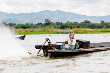Inle Lake, Myanmar - 30 Ağustos 2016: Myanmar'ın Shan Eyaletinin Taunggyi İlçesi'nin Nyaungshwe İlçesi'nde bulunan bir tatlı su gölü olan Inle Sap'ın üzerinde bambu teknede bulunan tanımlanamayan Birmanyalı adam