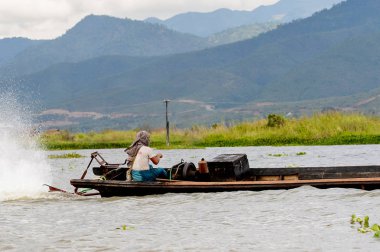 Inle Lake, Myanmar - 30 Ağustos 2016: Myanmar'ın Shan Eyaletinin Taunggyi İlçesi'nin Nyaungshwe İlçesi'nde bulunan bir tatlı su gölü olan Inle Sap'ın üzerinde bambu teknede bulunan tanımlanamayan Birmanyalı adam