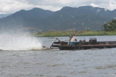 Inle Lake, Myanmar - 30 Ağustos 2016: Myanmar'ın Shan Eyaletinin Taunggyi İlçesi'nin Nyaungshwe İlçesi'nde bulunan bir tatlı su gölü olan Inle Sap'ın üzerinde bambu teknede bulunan tanımlanamayan Birmanyalı adam
