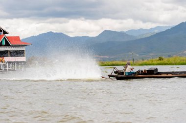 Inle Lake, Myanmar - 30 Ağustos 2016: Myanmar'ın Shan Eyaletinin Taunggyi İlçesi'nin Nyaungshwe İlçesi'nde bulunan bir tatlı su gölü olan Inle Sap'ın üzerinde bambu teknede bulunan tanımlanamayan Birmanyalı adam