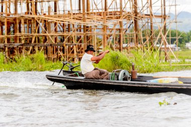 Inle Lake, Myanmar - 30 Ağustos 2016: Myanmar'ın Shan Eyaletinin Taunggyi İlçesi'nin Nyaungshwe İlçesi'nde bulunan bir tatlı su gölü olan Inle Sap'ın üzerinde bambu teknede bulunan tanımlanamayan Birmanyalı adam