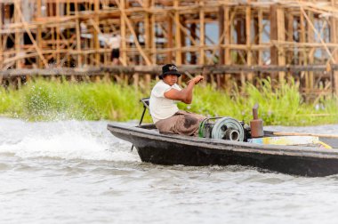 Inle Lake, Myanmar - 30 Ağustos 2016: Myanmar'ın Shan Eyaletinin Taunggyi İlçesi'nin Nyaungshwe İlçesi'nde bulunan bir tatlı su gölü olan Inle Sap'ın üzerinde bambu teknede bulunan tanımlanamayan Birmanyalı adam