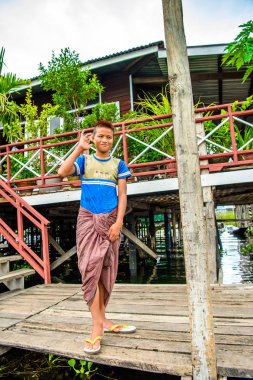 Inle Lake, Myanmar - 30 Ağustos 2016: Inle gölünün iskelesinde tanımlanamayan Birmanyalı çocuk. Myanma halkının yüzde 68'i Bamar etnik grubuna mensandı
