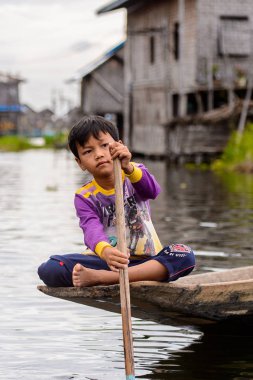 Inle Lake, Myanmar - 30 Ağustos 2016: Myanmar'ın Shan Eyaletinin Taunggyi İlçesi'nin Nyaungshwe İlçesi'nde bulunan bir tatlı su gölü olan Inle Sap'ın üzerinde bambu teknede bulunan tanımlanamayan Birmanyalı çocuk